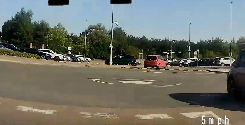 A car approaching a mini-roundabout junction with a painted central circle