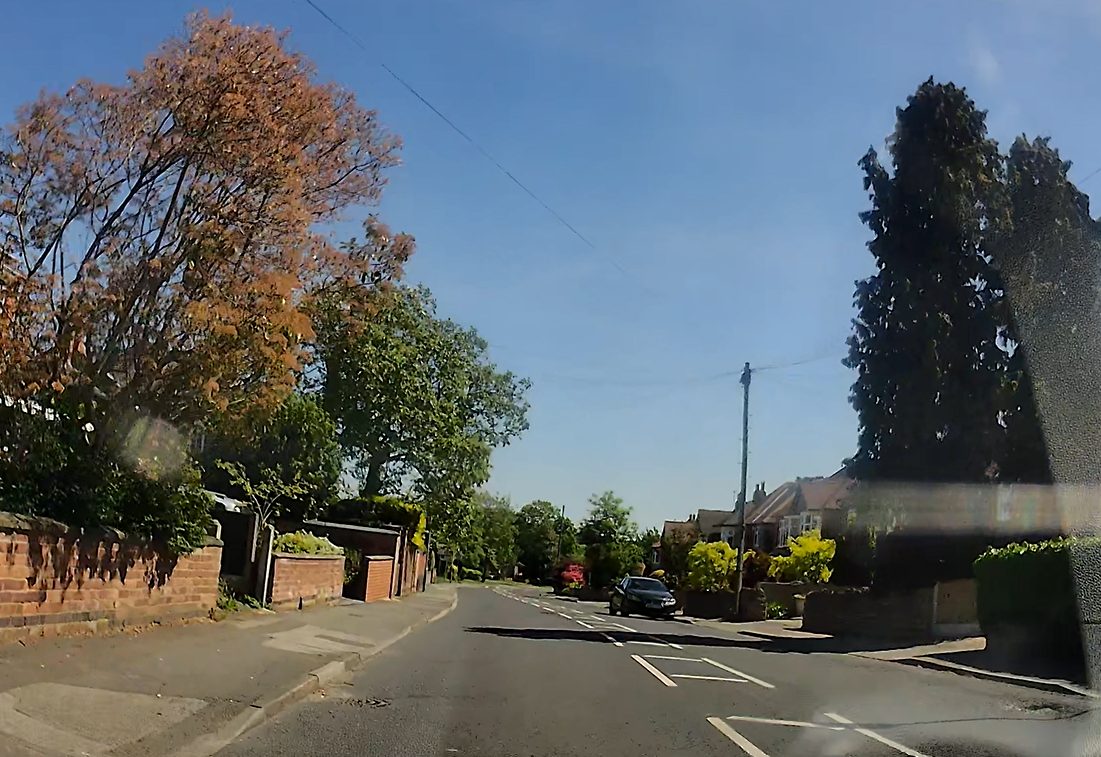 Automatic car checking mirrors and blind spot before moving off on a Nottingham street